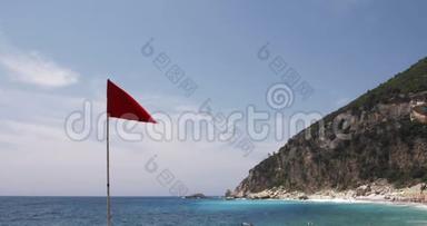 海滩上的红色警示旗，蓝色的大海，天空和陆地背景下的一个€“风与海夏日视频”
